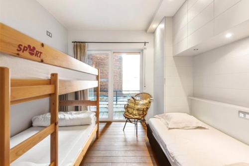 a bedroom with two bunk beds and a chair at Apartment Entre Ciel et Mer in Knokke-Heist