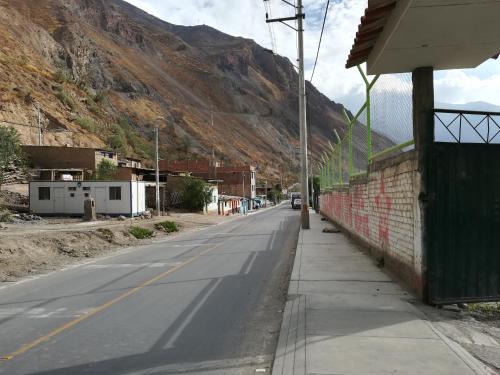 an empty street with a mountain in the background at Hospedaje T&T in Churín