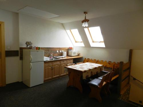 a kitchen with a table and a white refrigerator at Penzión Soňa in Ždiar