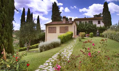 dom w ogrodzie z kamienną ścieżką w obiekcie Monolocale il vecchio fienile w mieście San Gimignano
