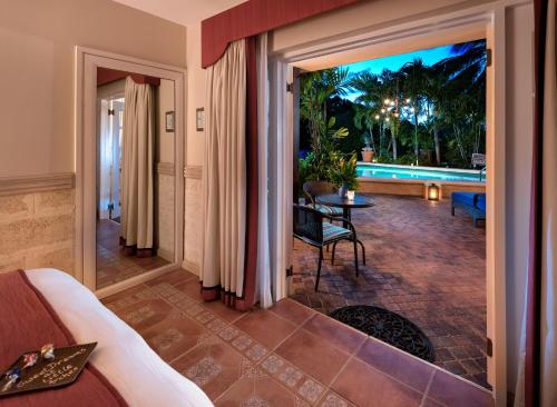 a living room with a view of a pool at Little Arches Boutique Hotel - Adults Only in Christ Church