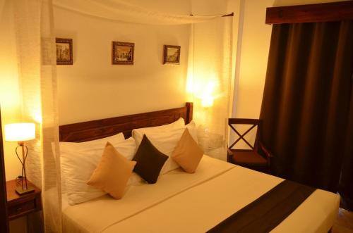a bedroom with a bed with white sheets and pillows at La Pasion Colonial Hotel Boutique By Bunik in Playa del Carmen