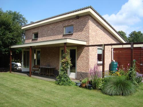 a brick house with a table in a yard at Vakantiehuis Petrarca in Putten