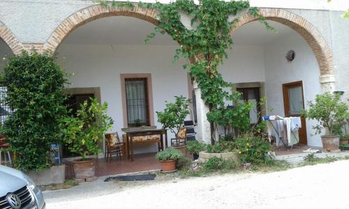 ein Gebäude mit zwei Bögen mit Pflanzen und einem Tisch in der Unterkunft Agriturismo Holle in Manerba del Garda