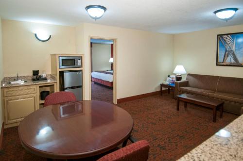 a hotel room with a table and a couch at Governors Suites Hotel Oklahoma City Airport Area in Oklahoma City