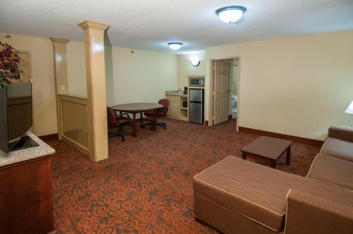 a living room with a couch and a table at Governors Suites Hotel Oklahoma City Airport Area in Oklahoma City