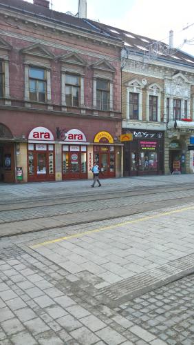 a person walking down a street in front of buildings at Széchenyi Apartman Miskolc belvárosban in Miskolc