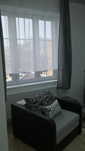a bed sitting in a room with a window at Széchenyi Apartman Miskolc belvárosban in Miskolc