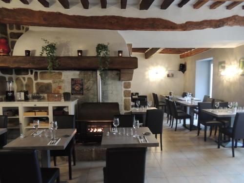 un restaurante con mesas y sillas y una chimenea en Hotel Restaurant La Calade, en Octon