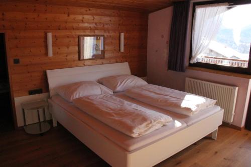 a bedroom with a bed with two pillows on it at Katharinahof Ferienpension in Sibratsgfäll