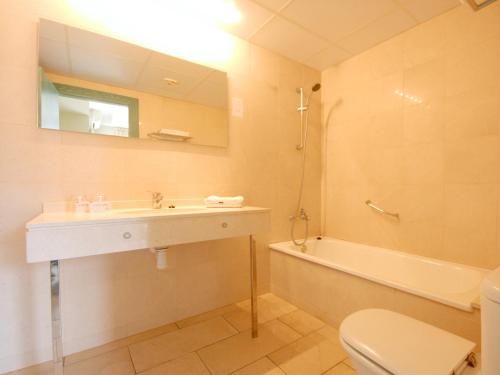 a bathroom with a sink and a toilet and a tub at Hotel Safari in Gandía