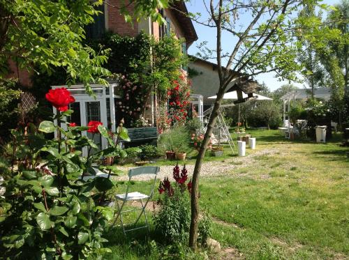 a garden with a bench and roses in a yard at Al Porretto in Madonna della Provvidenza