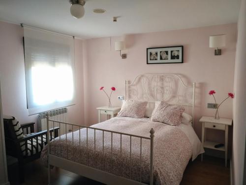 een slaapkamer met een bed met roze muren en een raam bij Alojamientos Palacete in Peñaranda de Duero