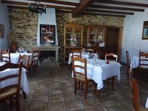 una sala da pranzo con tavoli, sedie e camino di Mesa del Conde a San Felices de los Gallegos