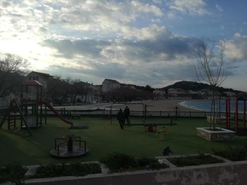 een park met een speeltuin met een glijbaan bij Apartman Ante in Murter