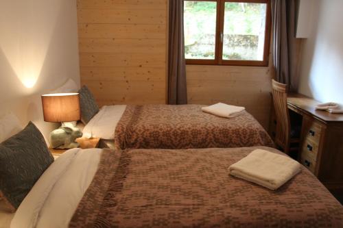 モルジヌにあるChalet Marmotte 3のベッド2台と窓が備わるホテルルームです。