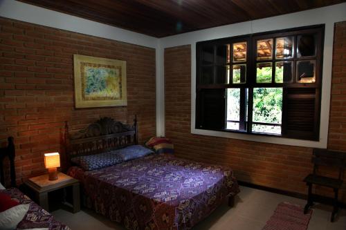 a bedroom with a bed and a brick wall at Casa de Penedo in Penedo