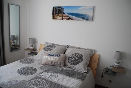1 dormitorio con 1 cama con una foto en la pared en Comme à la maison en Gujan-Mestras