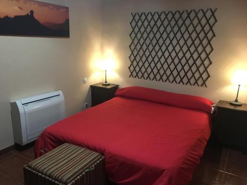 a red bed in a room with two lamps at Villa Rafael in Vega de San Mateo
