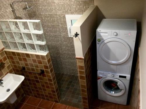 a bathroom with a washing machine and a sink at Villa Rafael in Vega de San Mateo