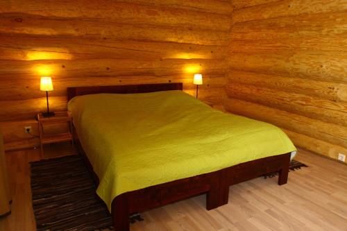 a bedroom with a bed in a log cabin at Asvejos slenis in Sužionys