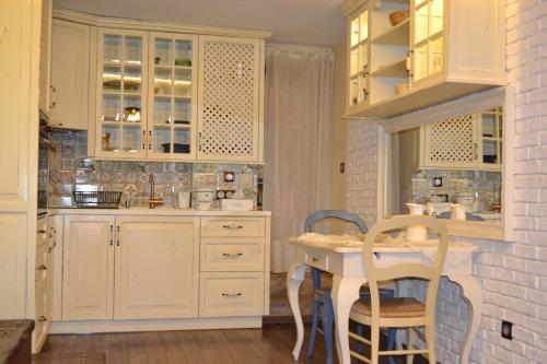 a kitchen with white cabinets and a table and chairs at Vintage Lozenets Apartment in Sofia