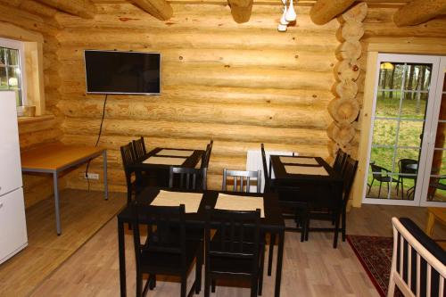 a dining room with a table and a television on a wall at Asvejos slenis in Sužionys