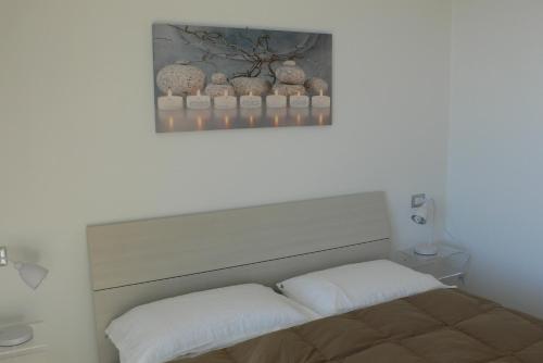 uma cama com duas almofadas e uma fotografia por cima em Perla del Lago em Carmine