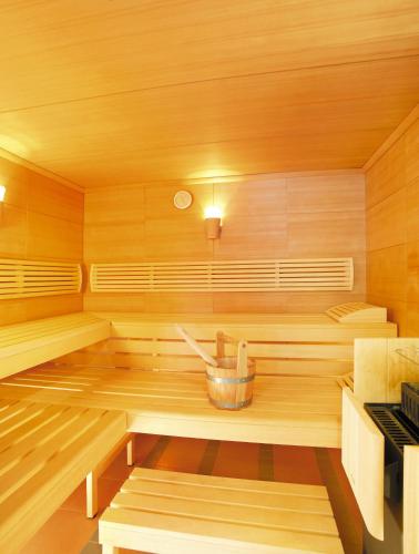 a wooden sauna with a bucket in the middle at Apart-Hotel Dreisonnenhof in Fiss