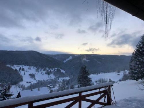 a view of a snow covered valley with a fence at Horský Ranč in Pec pod Sněžkou