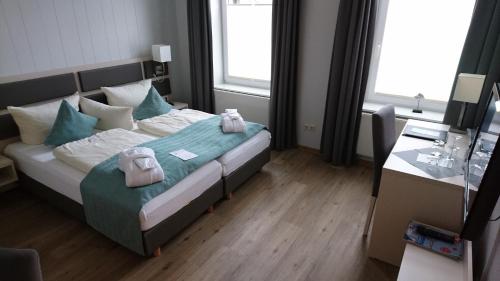 a bedroom with a bed with towels on it at Hotel Sylter Hof in Westerland (Sylt)