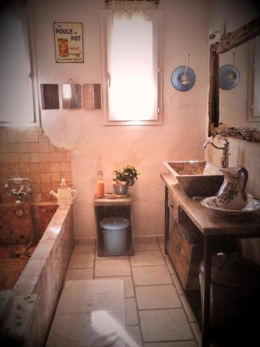 une petite salle de bain avec un lavabo et une fenêtre dans l'établissement les trésors de malle mialle, au Thor