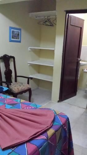 a room with a bed and a chair and a shelf at B&B KeisyAlba Punta Rucia in Punta Rucia