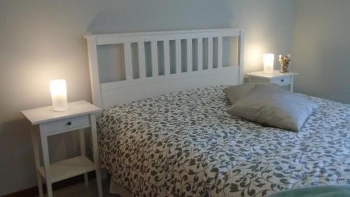 a bedroom with a bed with two white night stands at Apartamento Urb. Vila Nova, Lote 5 in Armação de Pêra
