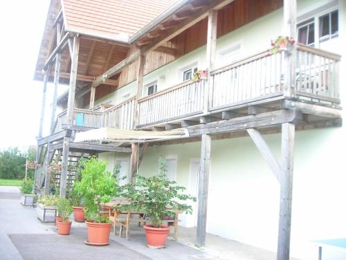 a building with a balcony and potted plants at Ferienwohnung Maier in Fürstenfeld