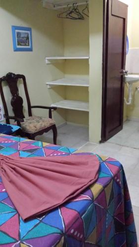 a room with a bed and a chair and shelves at B&B KeisyAlba Punta Rucia in Punta Rucia