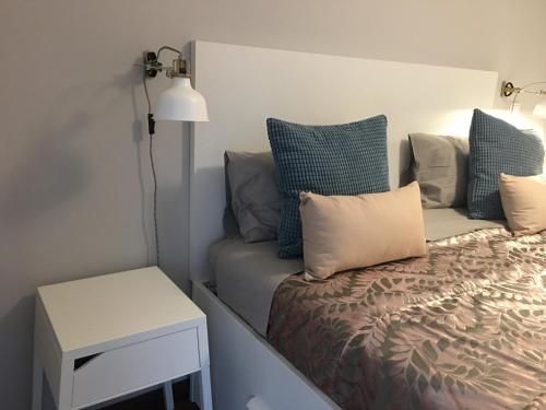 Un dormitorio con una cama con almohadas azules y una mesa. en Invicta House Serpa Pinto, en Oporto
