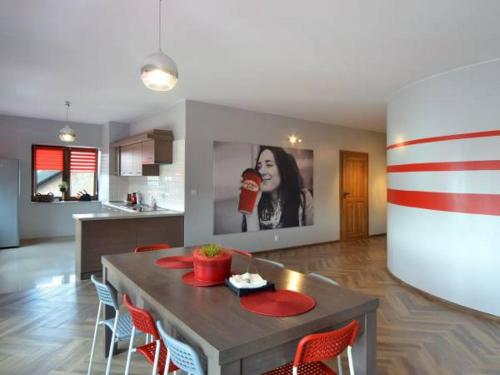 a kitchen with a table with chairs and a picture of a woman at Pokoje Staromiejski in Uniejow