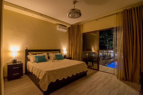 1 Schlafzimmer mit einem Bett mit 2 Lampen und einem Balkon in der Unterkunft Caribbean Diamond Boutique Hotel in Sosúa