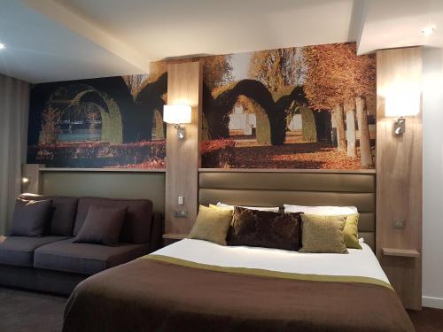 a bedroom with a large bed and a couch at Logis - Le Christina in Bourges