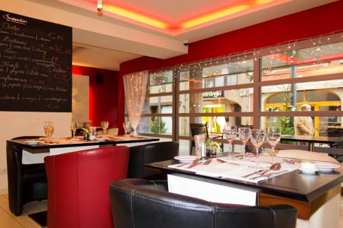 a restaurant with a bar with wine glasses at Hotel De Croone in Ninove