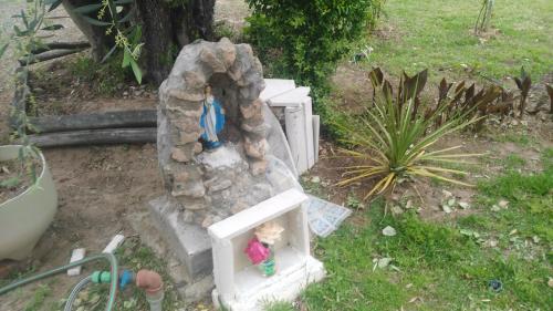 une statue d'un homme assis sur une tombe en pierre dans l'établissement Cabañas Terra Olivo, à Coquimbito