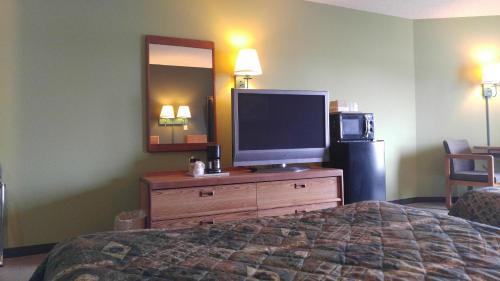 a hotel room with a bed and a television on a dresser at Harbor Lights Lodge in Kewaunee