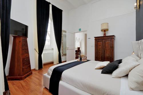 een slaapkamer met een groot wit bed en een televisie bij Dolce Casa Colosseo in Rome