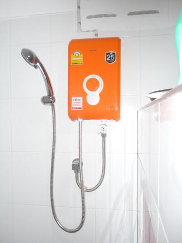 an orange shower head in a bathroom at Room For You in Bangkok
