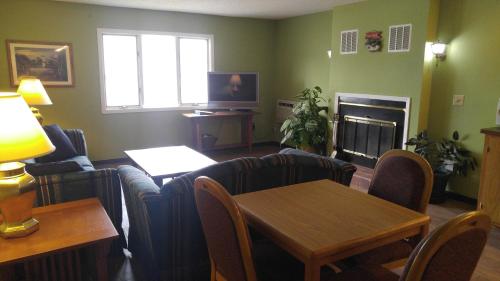 a living room with a couch and a table and a fireplace at Harbor Lights Lodge in Kewaunee