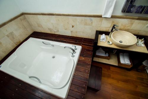 
a bathroom with a bath tub and a sink at Hotel Boutique Hacienda Guadalupe in San Miguel de Allende
