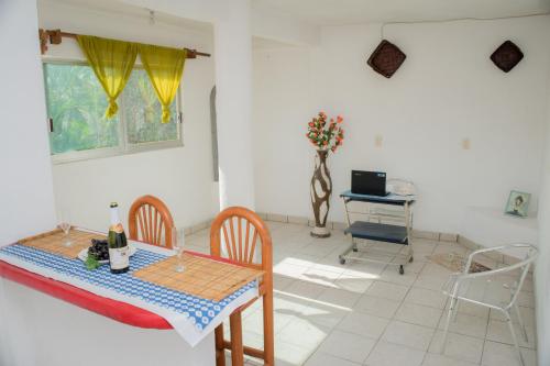a dining room with a table and a chair at Las Palmas in Zihuatanejo