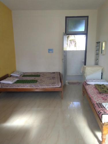 a room with two beds in it with a window at Holiyday in VGF Farm House in Dānishpet