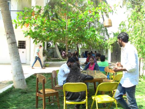 a group of people sitting at a table at Holiyday in VGF Farm House in Dānishpet